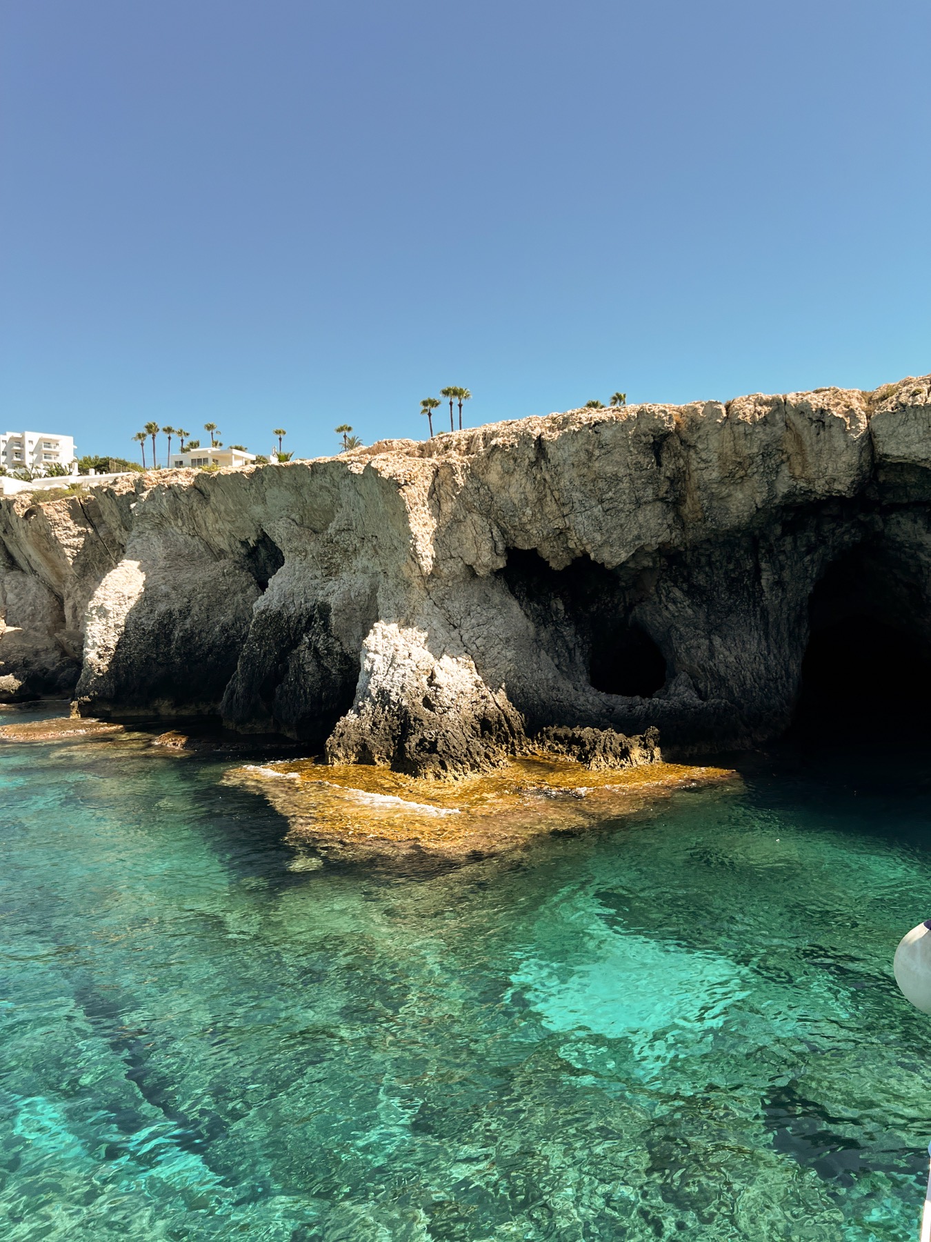 Close view of rocky caves above clear turquoise water