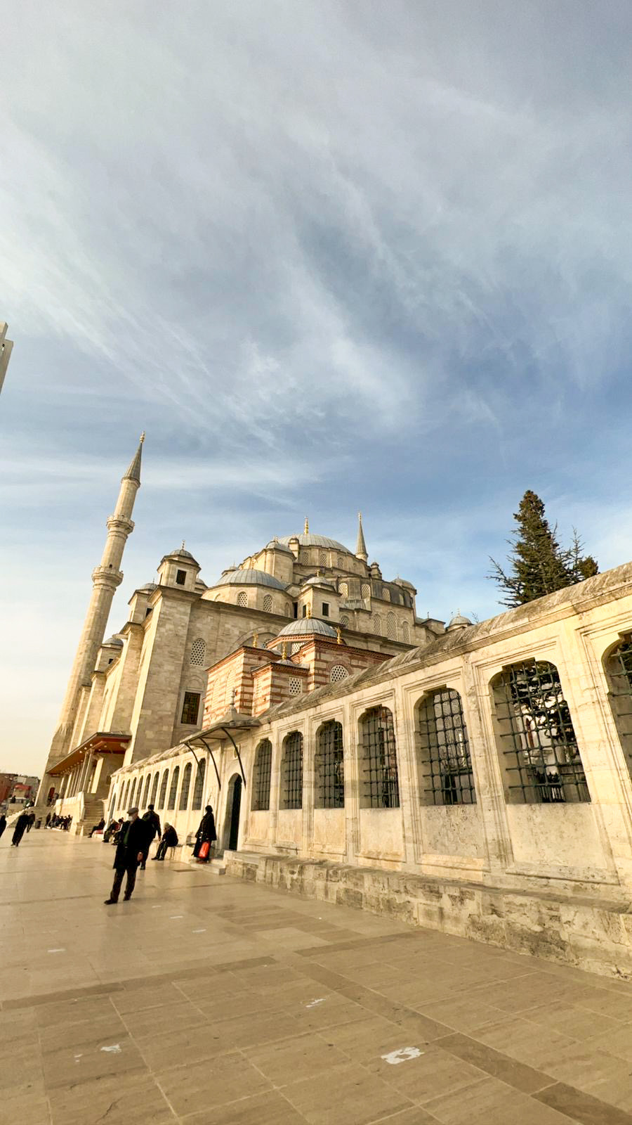Mosque seen across a pale stone courtyard