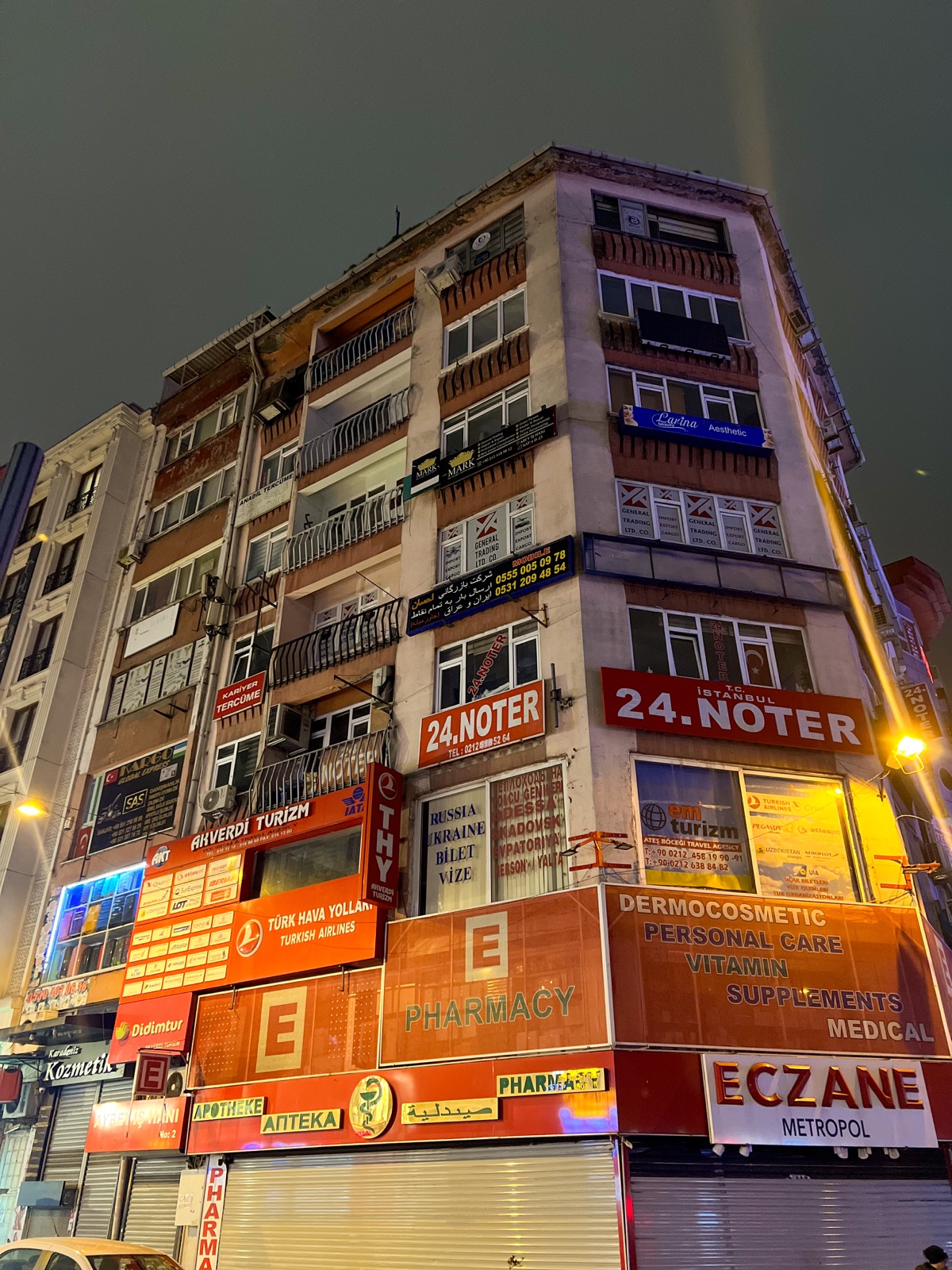 A tall Istanbul building covered in illuminated signs