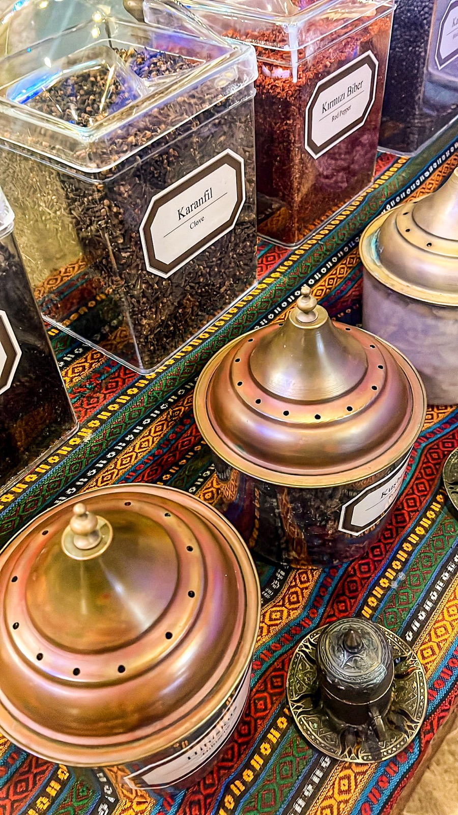 Spices displayed in jars on a colourful woven cloth